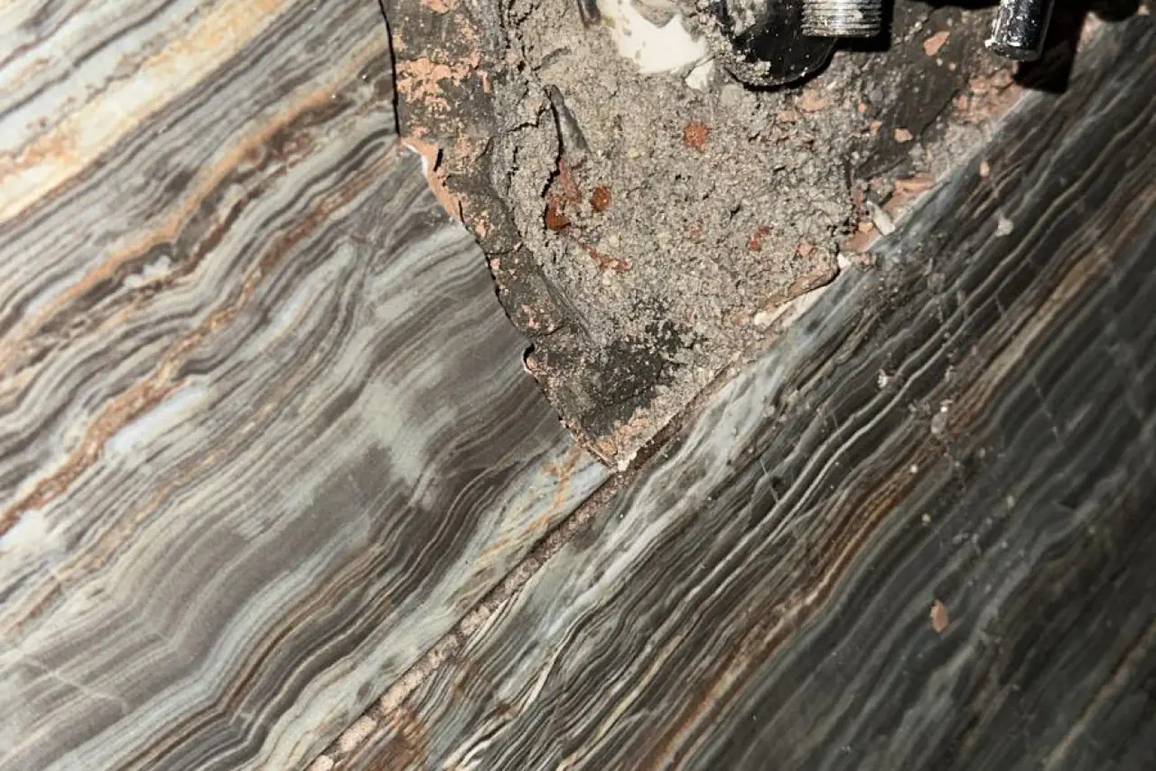 Duvar kaplaması altında erişilen metal vana ve boru bağlantısı