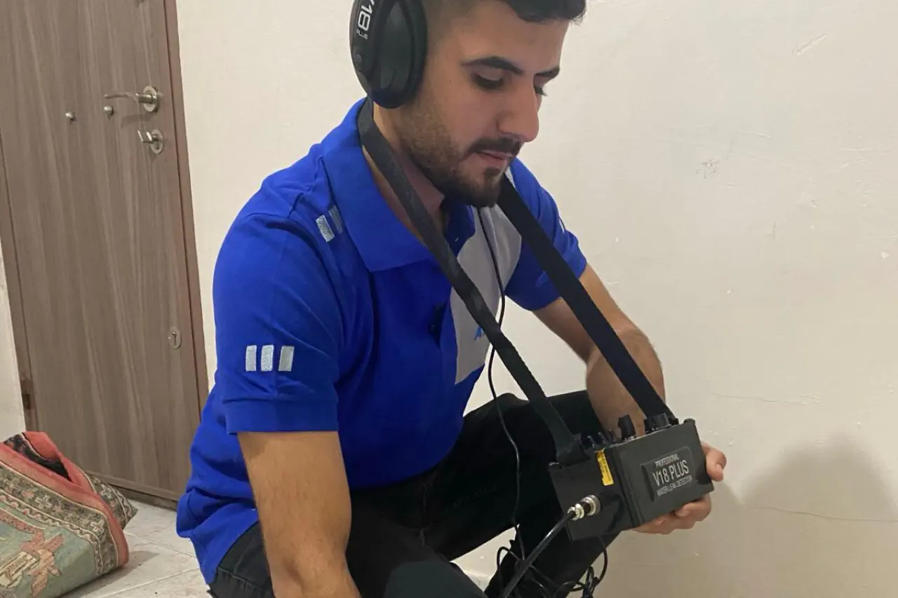 Akustik dinleme ekipmanıyla zemindeki tesisat sesini kontrol eden teknisyen